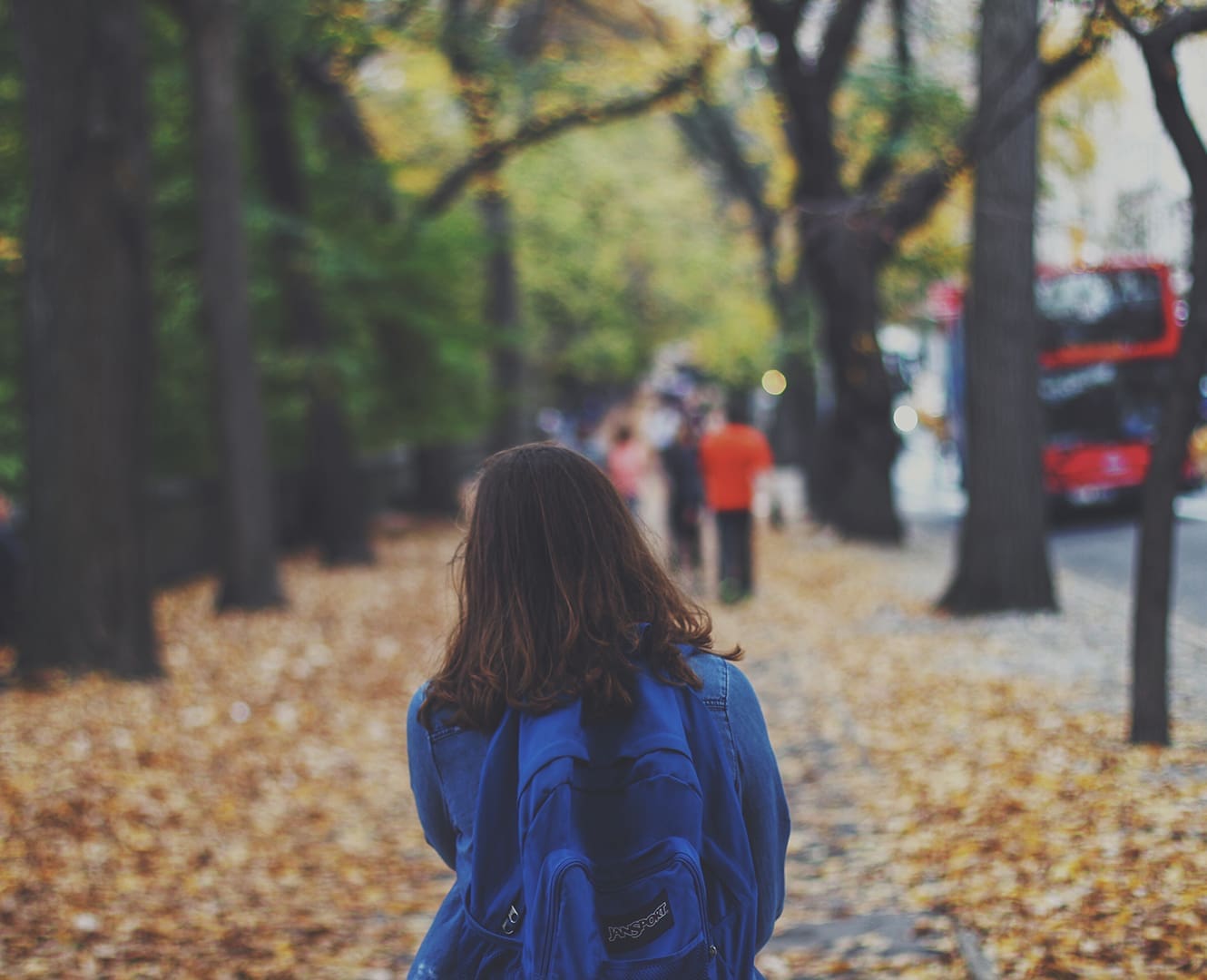 student walking down autumn path