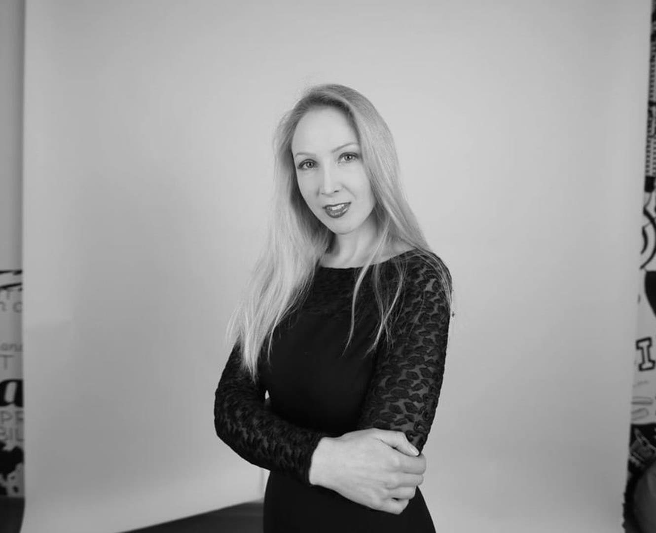 Russian woman stands in front of art display.