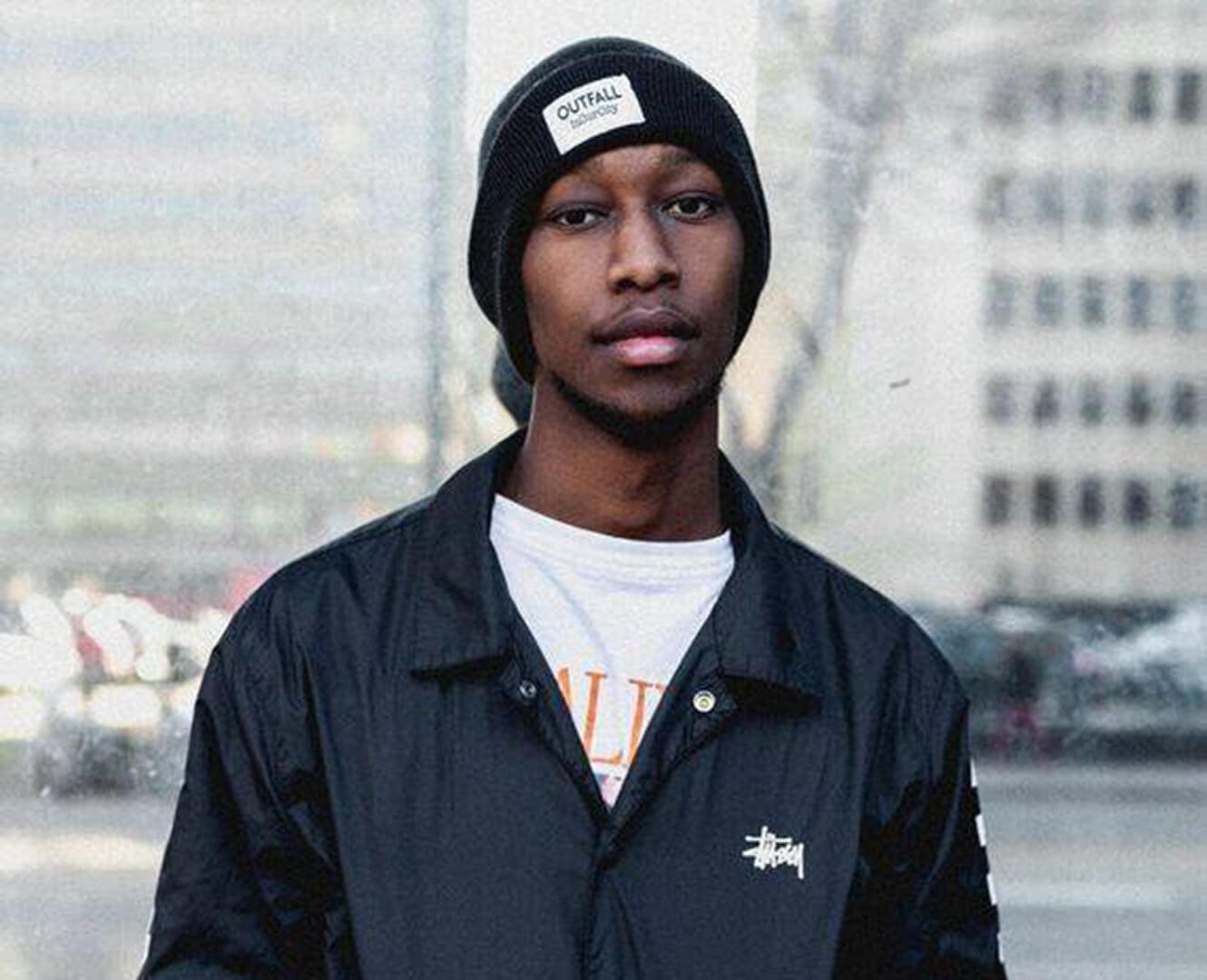 African American man stands on busy street