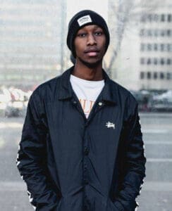 African American man stands on busy street