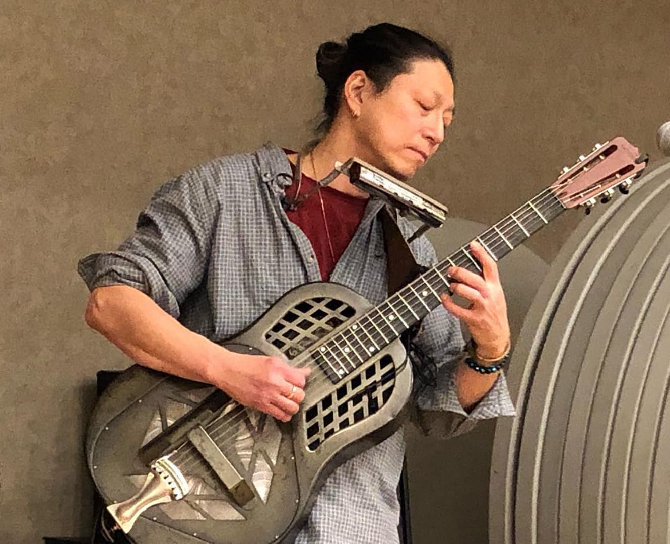 Japanese man plays guitar outdoors on the street