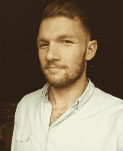 Man stands smirking for camera