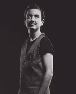 Man stands in vest looking towards sky