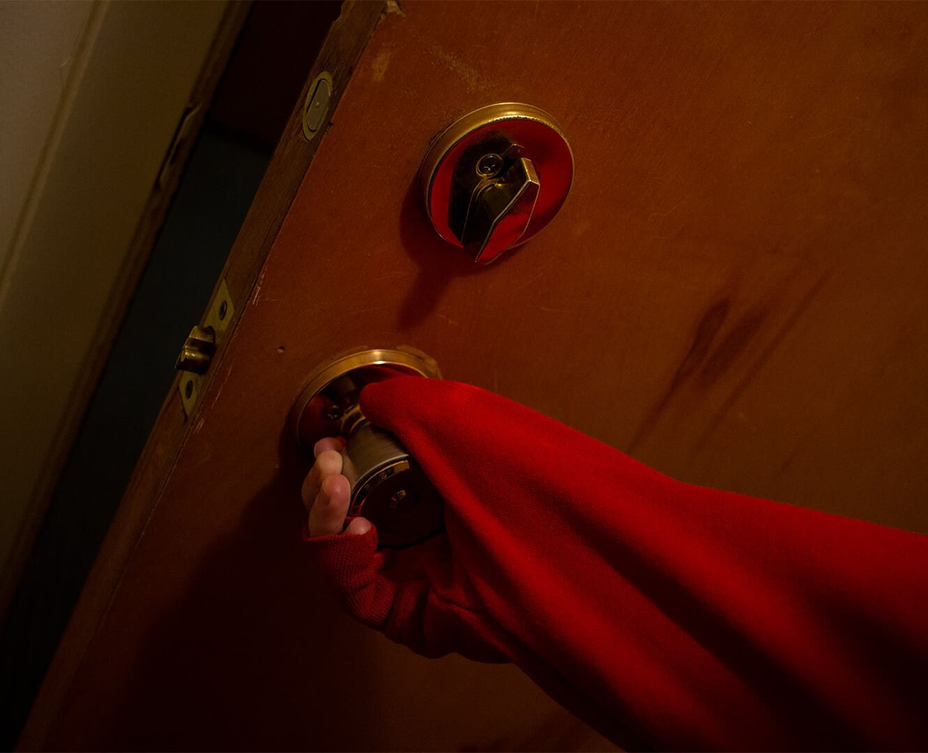 man opening door with sleeve protecting hand