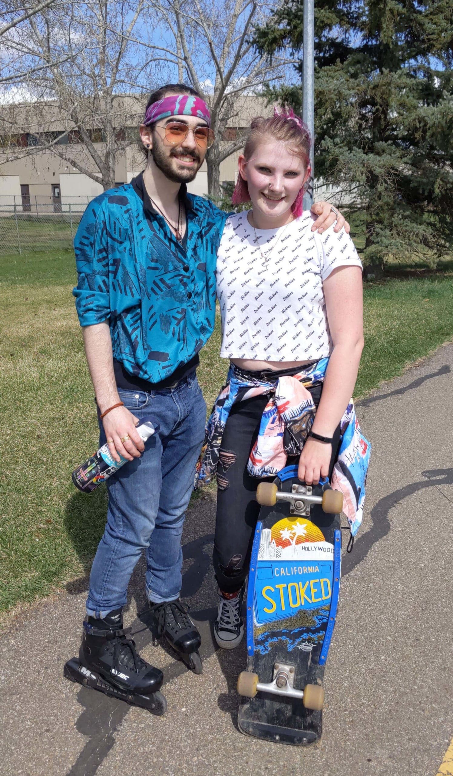Man and woman pose while skateboarding