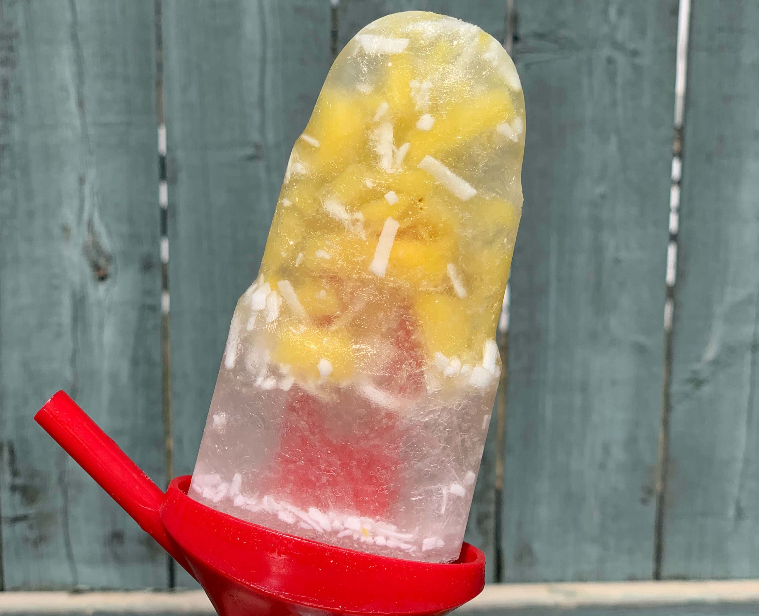 7 best boozy popsicle recipes Blonde girl holding orange popsicle