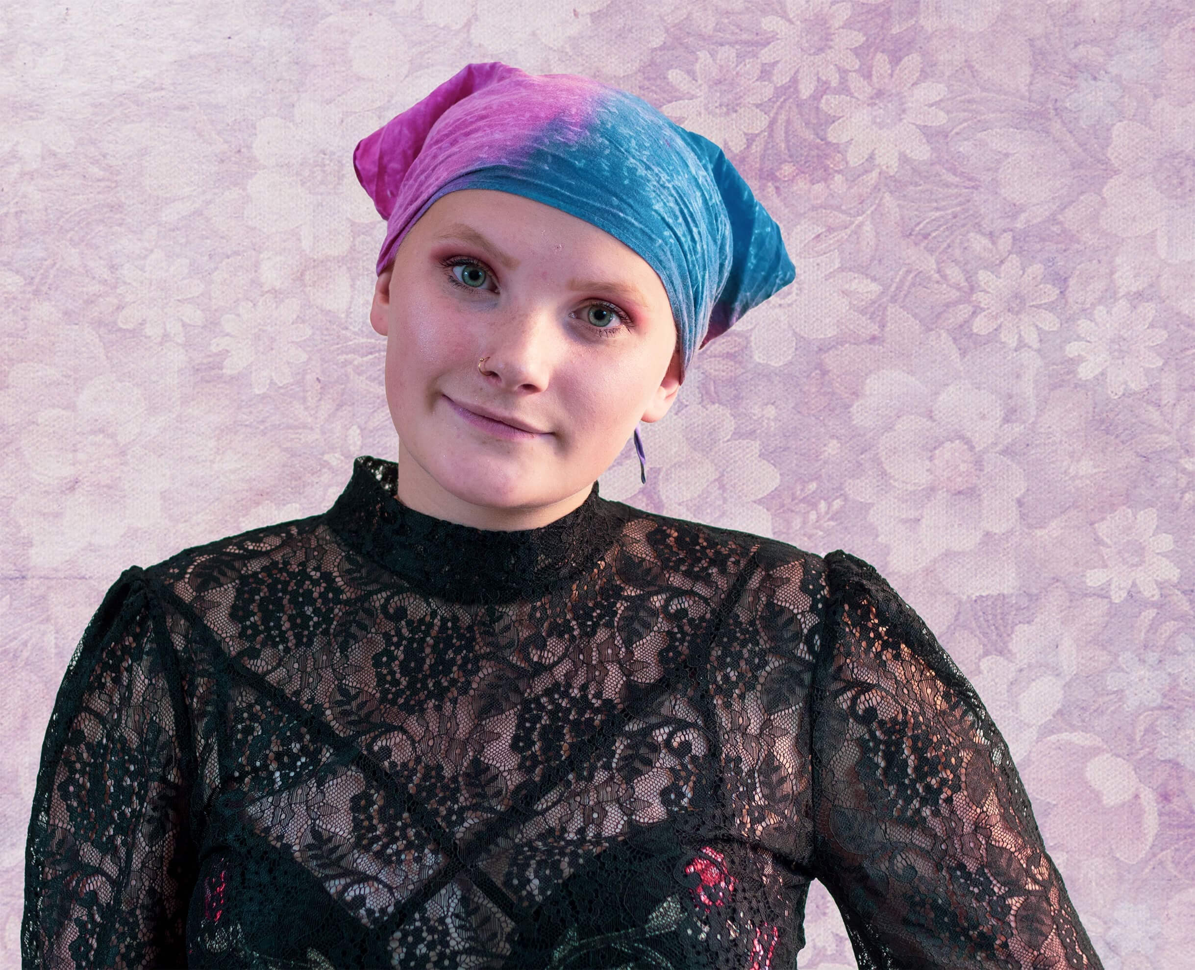 Woman wearing pink and blue bandana faces camera