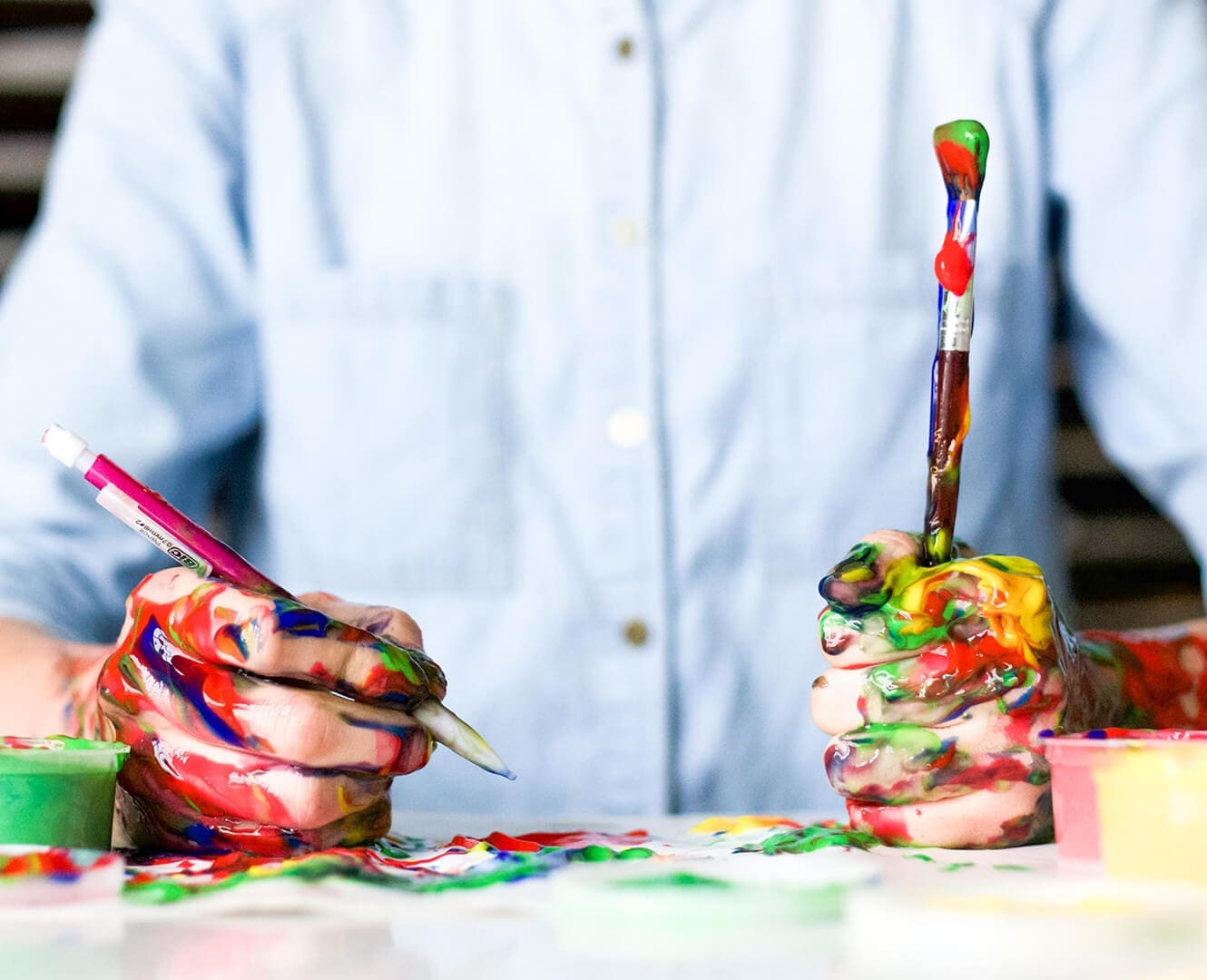 Person painting with their hands covered in paint.