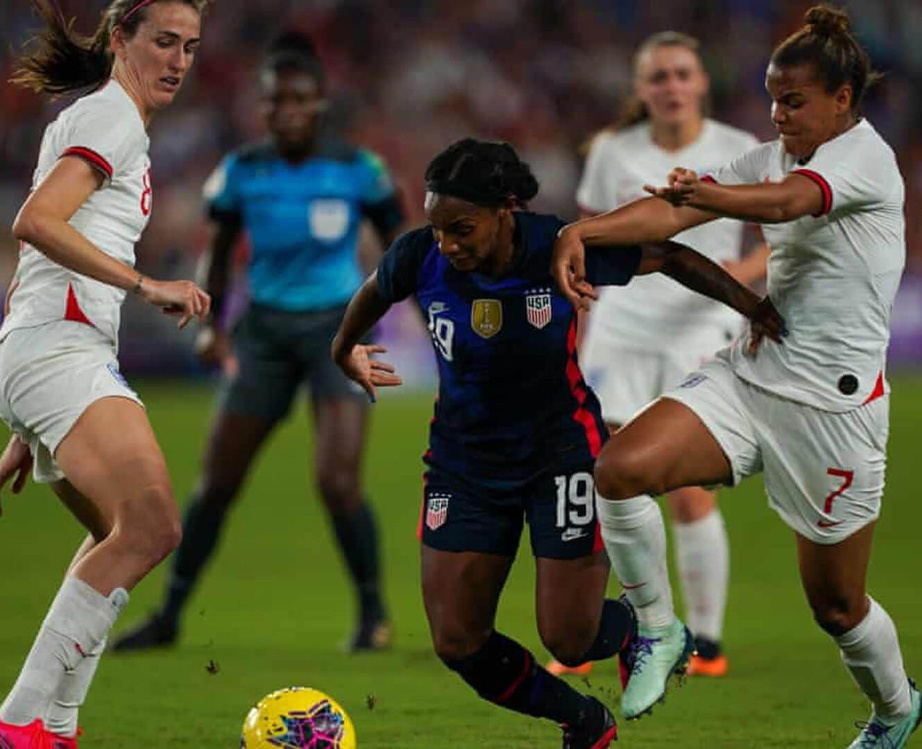 Female soccer players kicking soccer ball