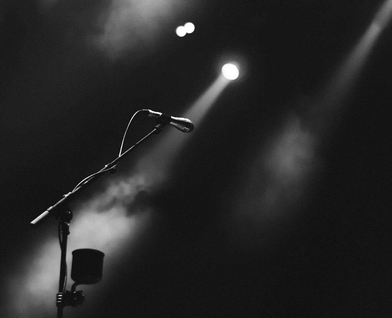 Microphone lit up by stage lights in dark room