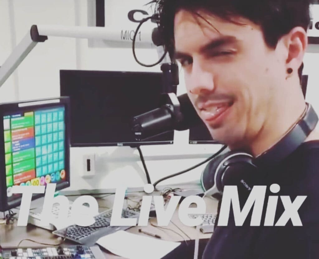 person sitting in front of radio mixing board.