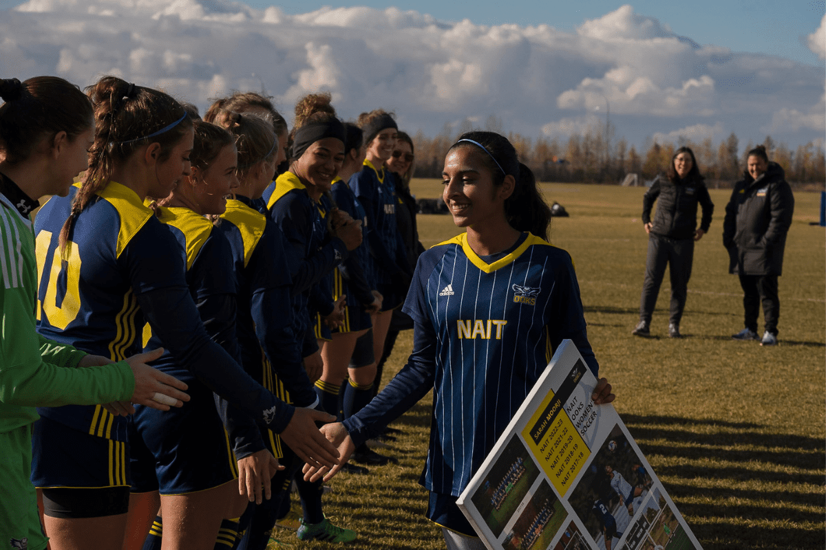 Sarah Moorji slaps hands with her teammates after receiving award.
