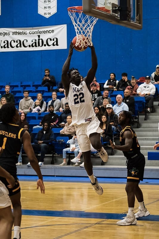 Nhiall Kuech jumps up to score a basket on the basketball court.