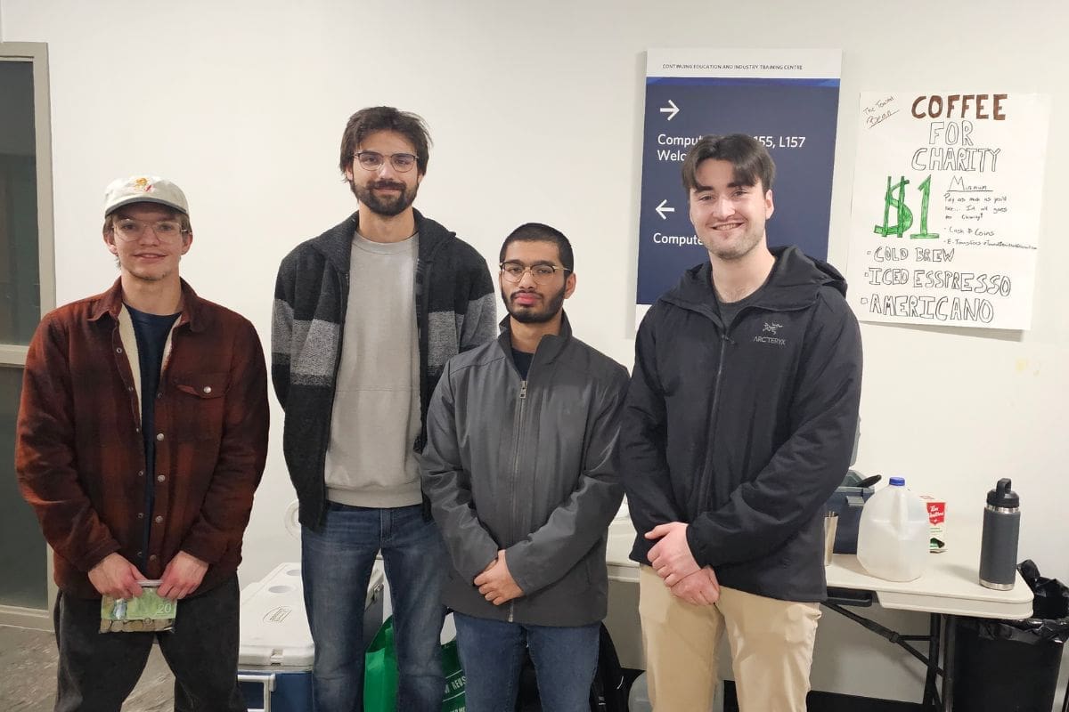 Members of the group "The Toasted Bean" pose outside their pop-up coffee shop at NAIT.