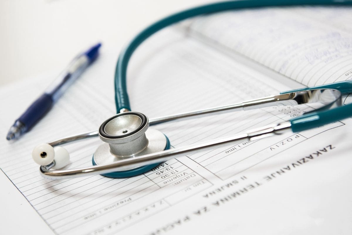 a stethoscope and pen lay on top of some paperwork