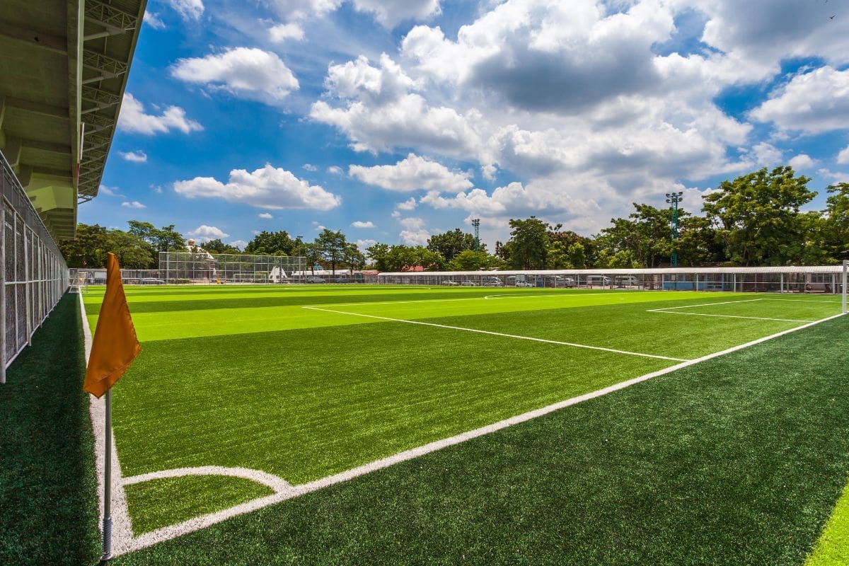 world cup soccer field a wide shot of a grassy soccer field. the sky is blue and filled with clouds.