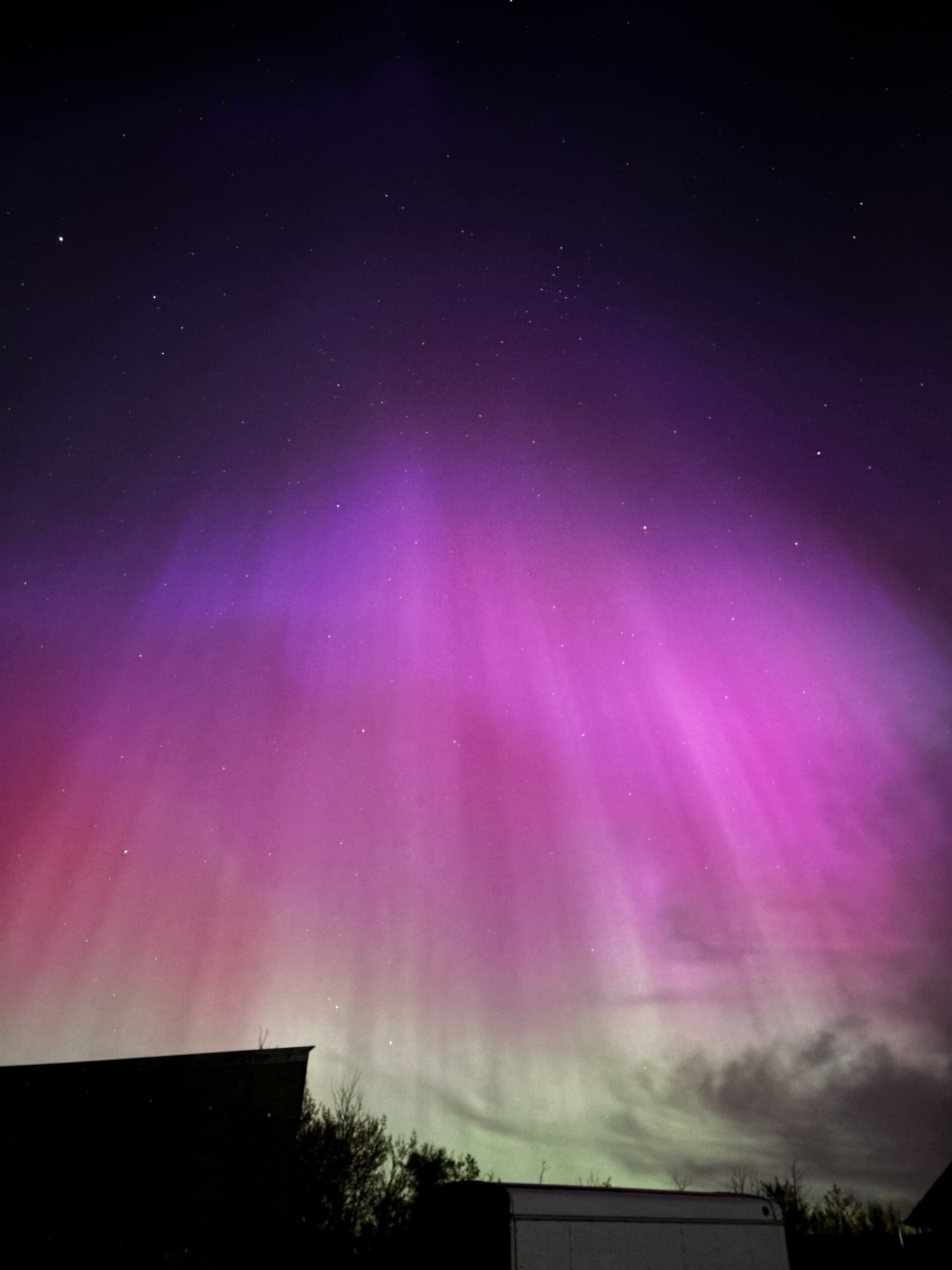 Aurora Borealis with dark purple, purple, pink, orange and light green colours.