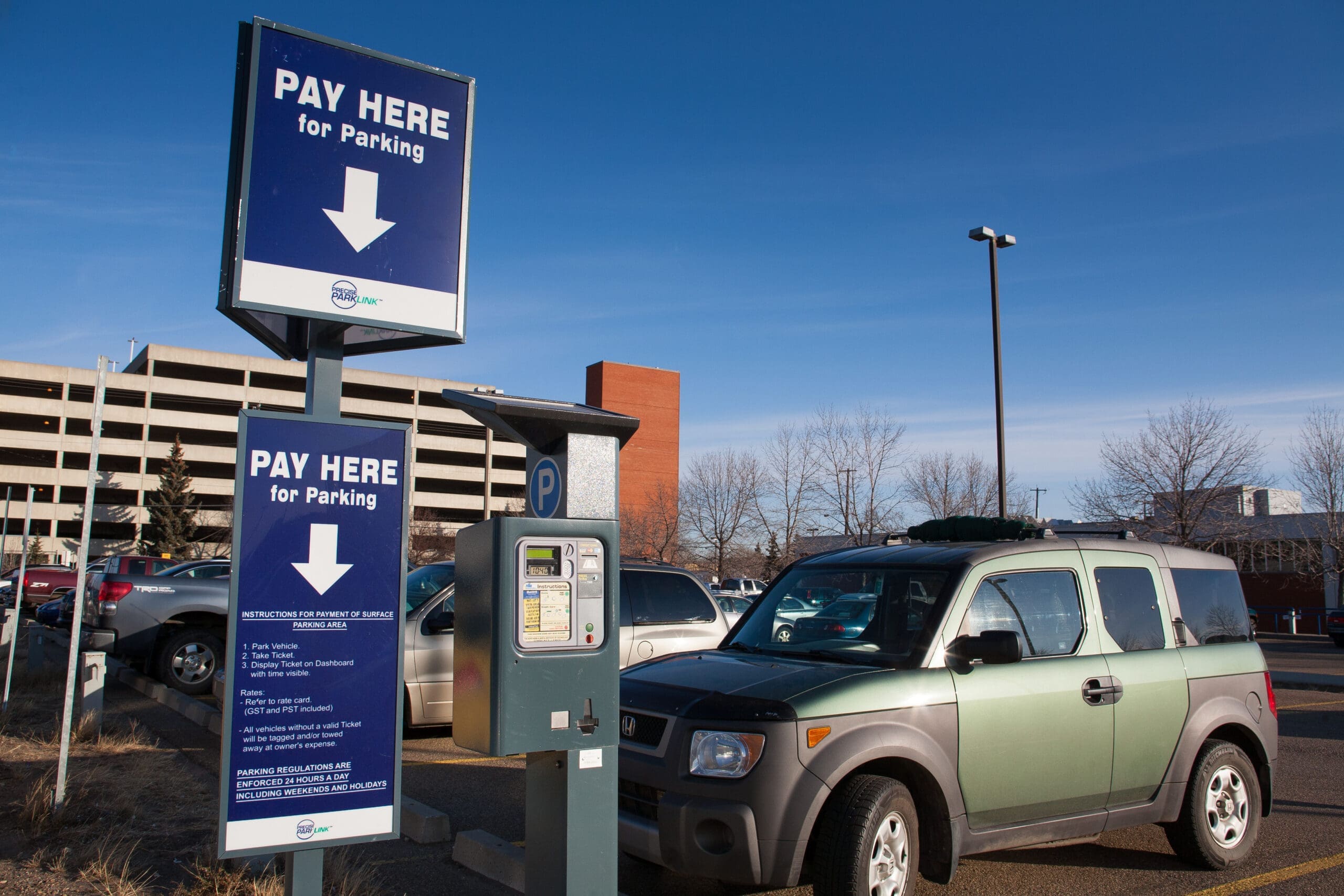 A pay here sign in one of NAIT's parking lots.
