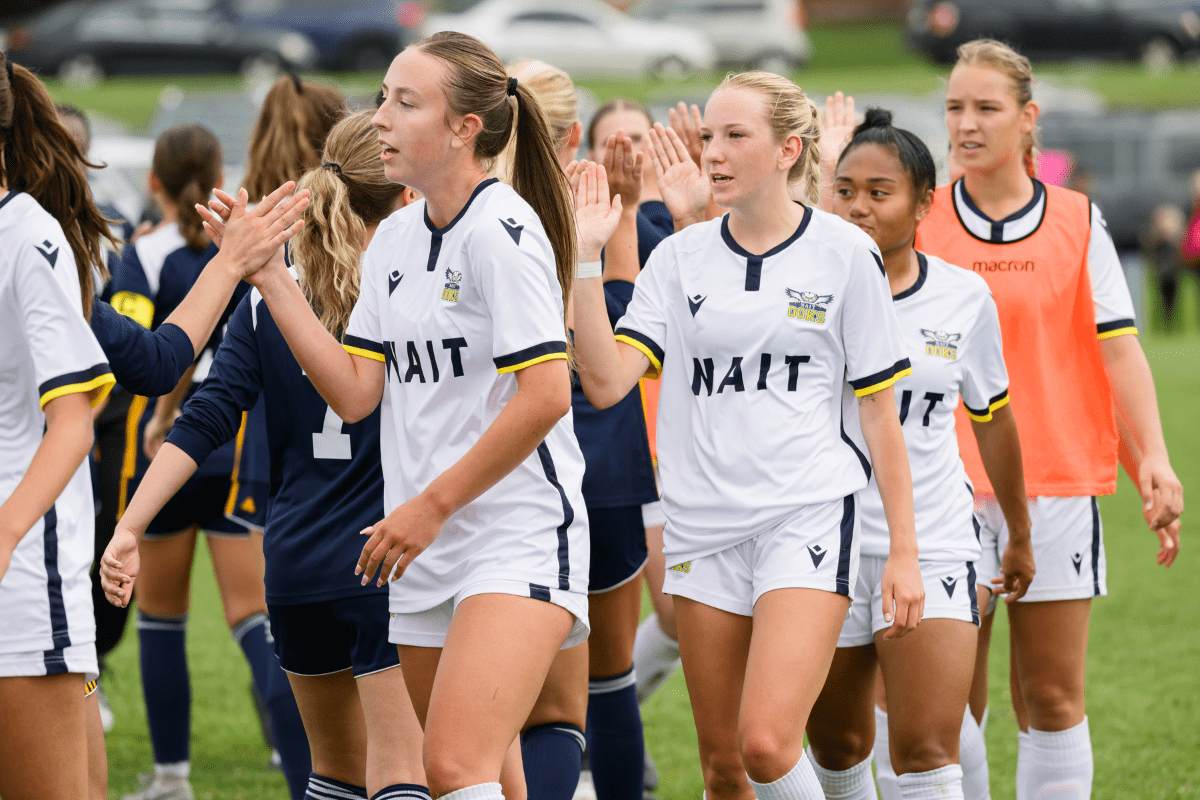 The NAIT Ooks women's soccer team shaking hands with opponents.