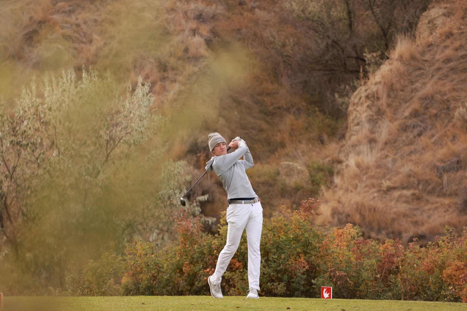 A NAIT Ooks golfer swinging a golf club.