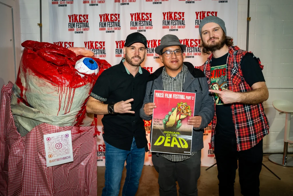 Chamberlin (right) stands next to Ross Paul and Edmon Rotea from SKINAMARINK at last year's YIKES! festival.