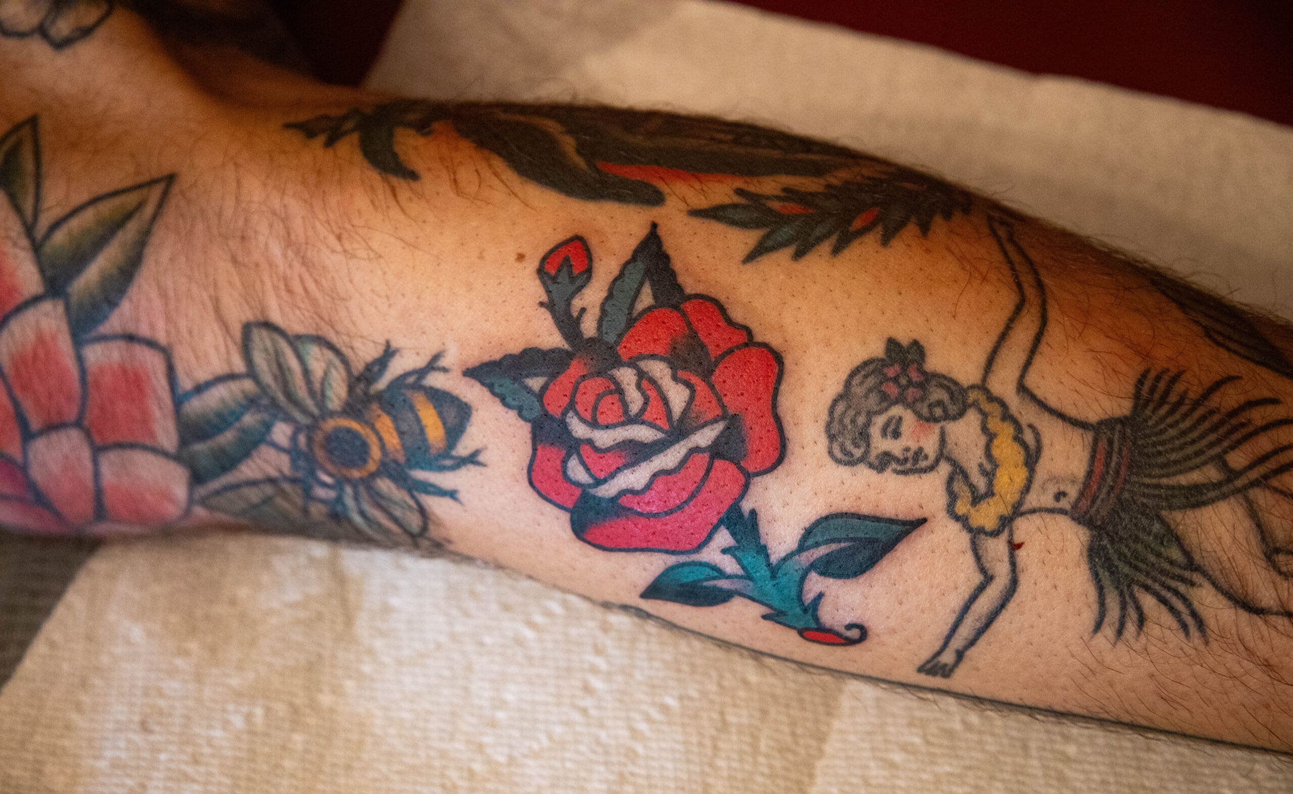 A traditional rose tattoo surrounded by other traditional pieces.