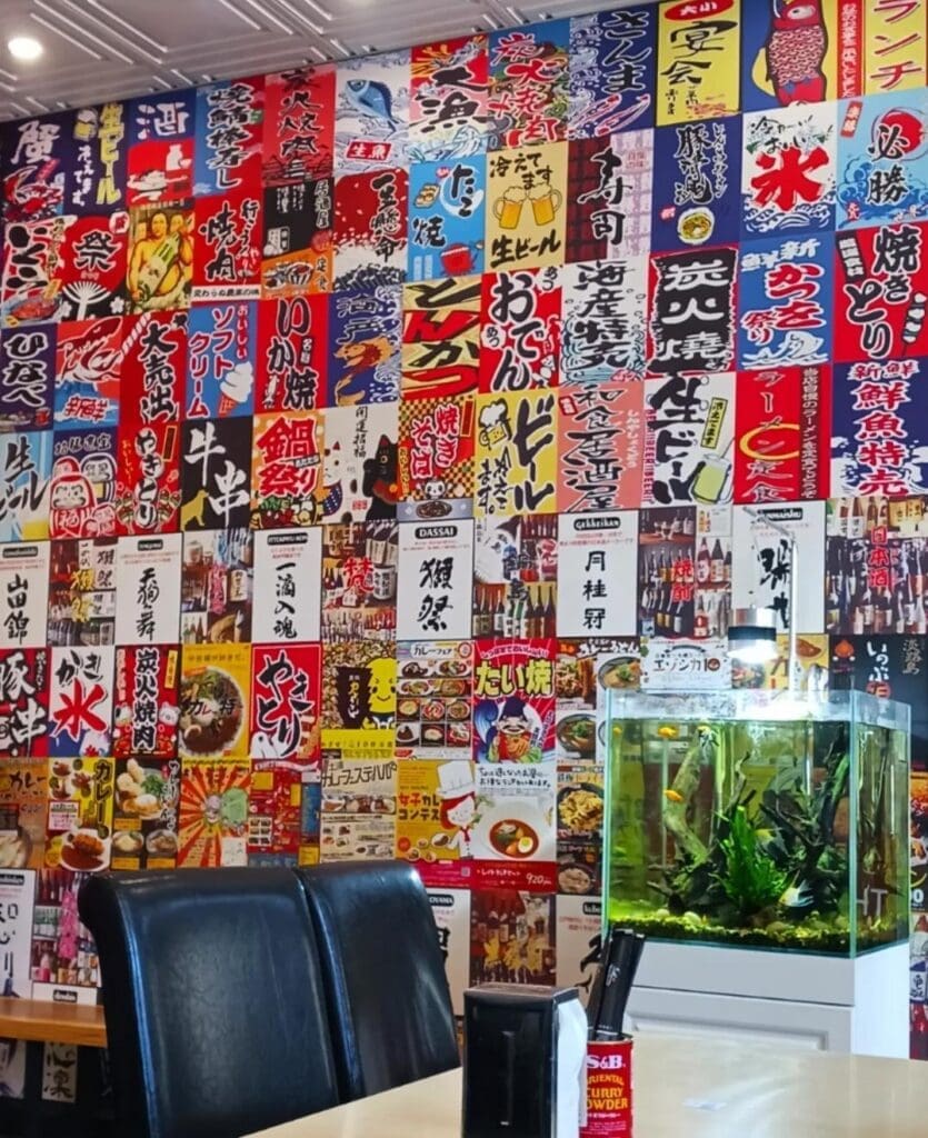 The interior of Donburi King has a colourful wall full of Japanese posters and a small fish tank.